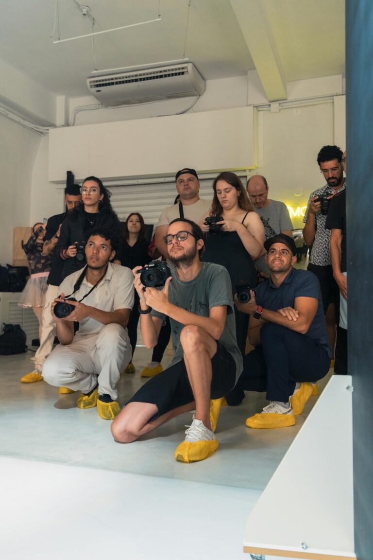 A diverse group of photographers in a studio setting capturing images.